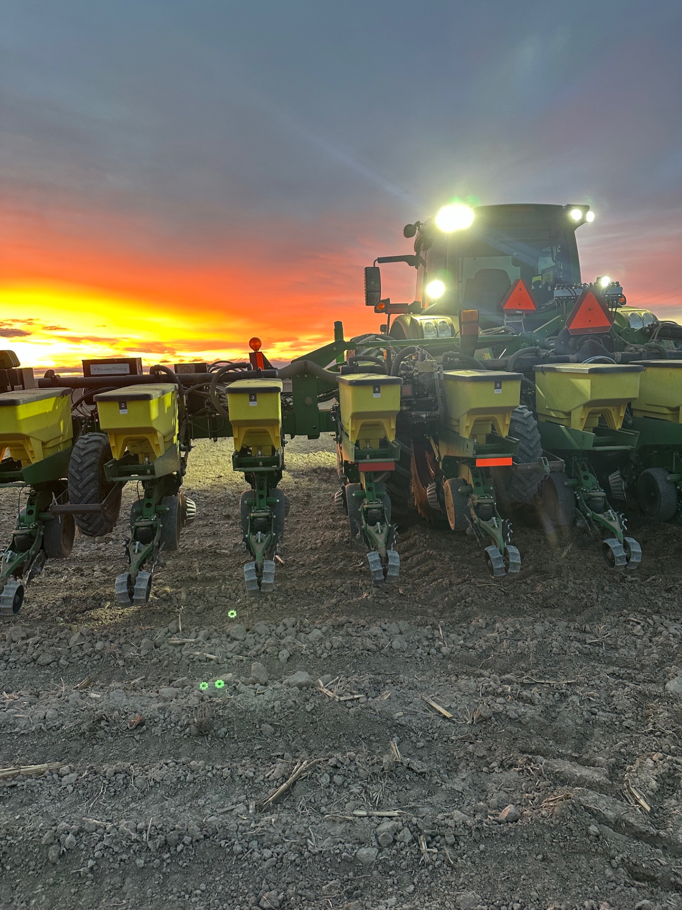 John Deere planter working a Colorado field at sunset